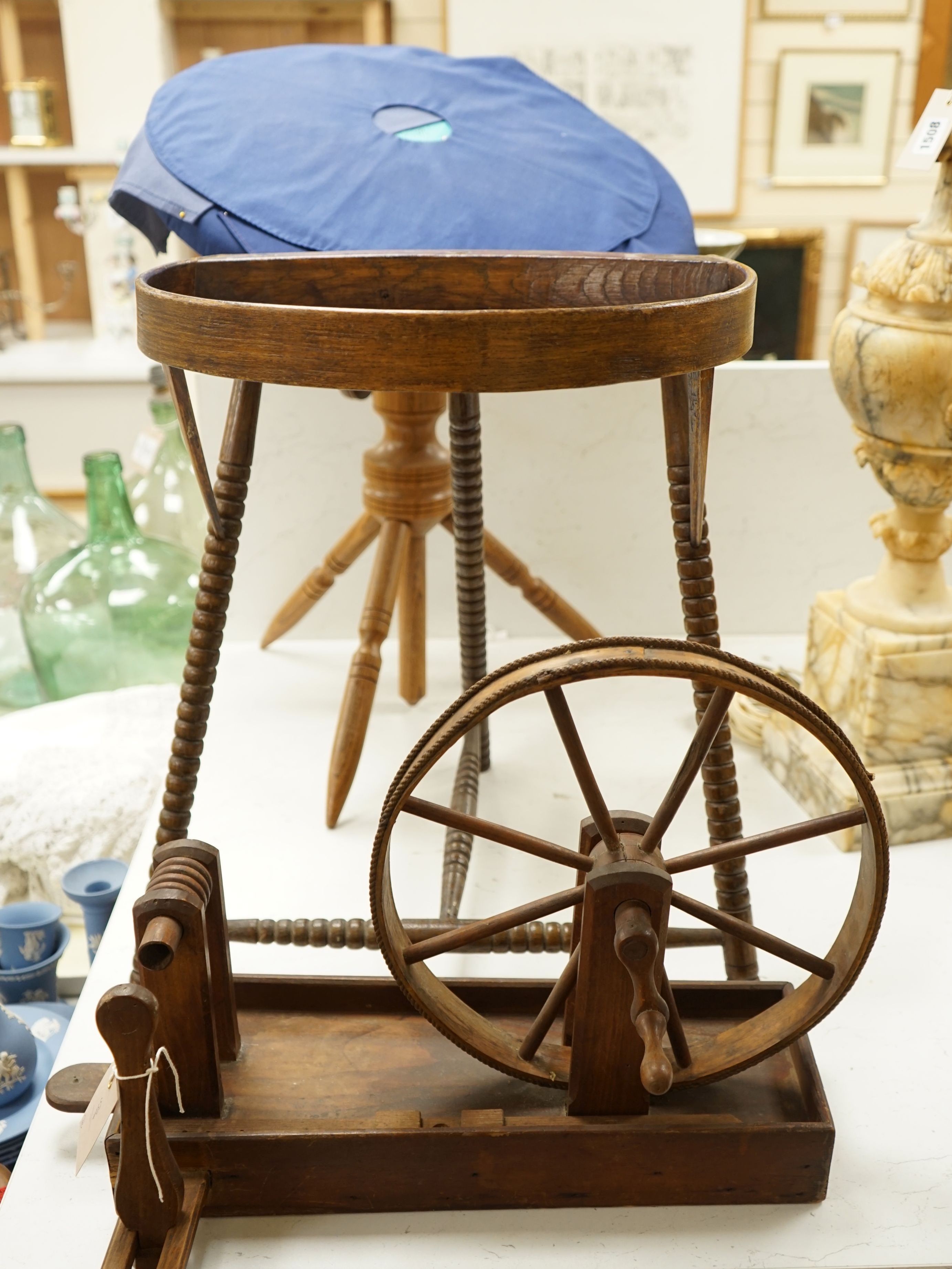 A lace pillow bolster stand, a lace bobbin winder and a lace maker's pillow on tripod stand